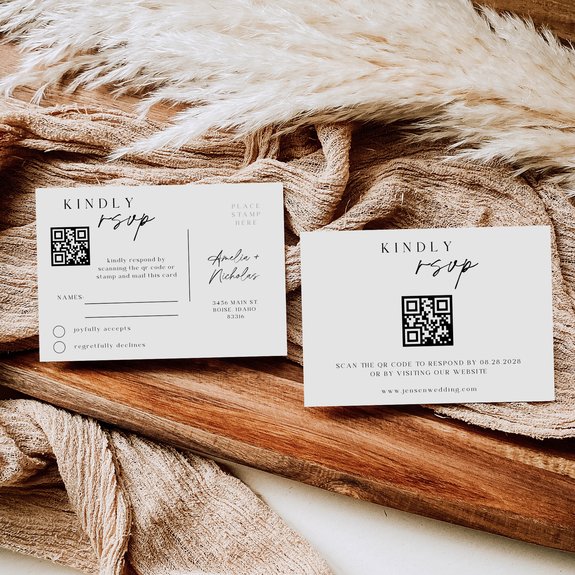 Two wedding RSVP cards with QR codes on a wooden surface with fabric.