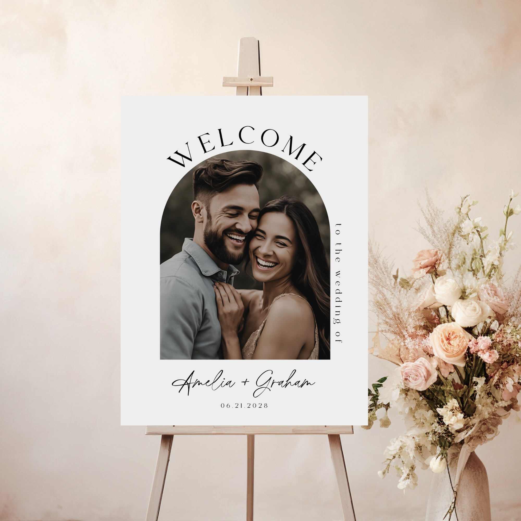 Welcome sign with a couple's photo and text on an easel with flowers.
