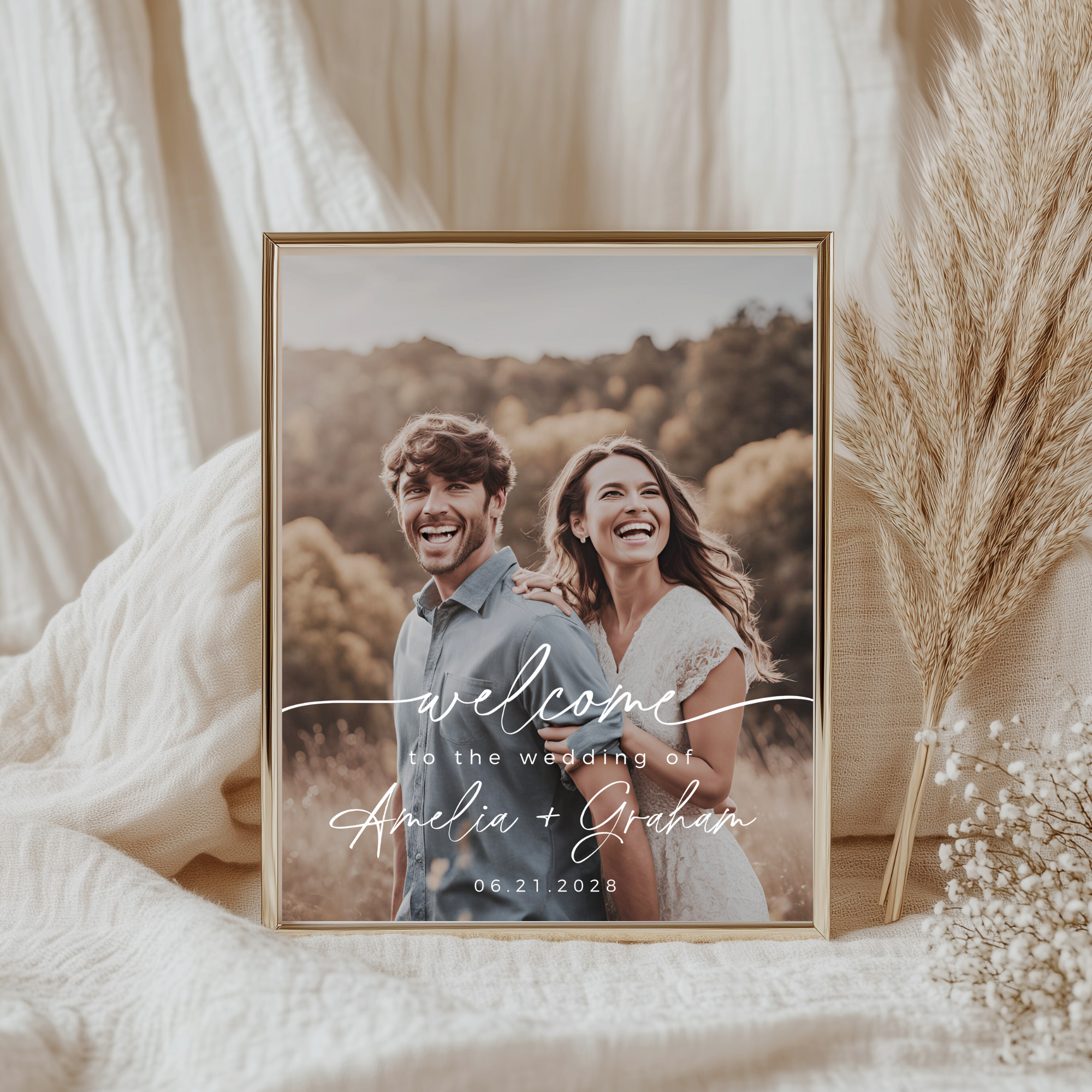 Framed photo of a couple with 'welcome to the wedding' text on a soft fabric background